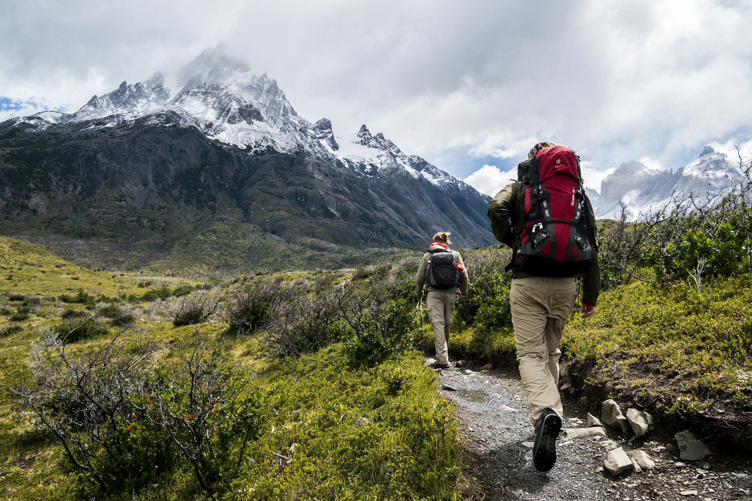 Hikers following a trail into a mountain valley