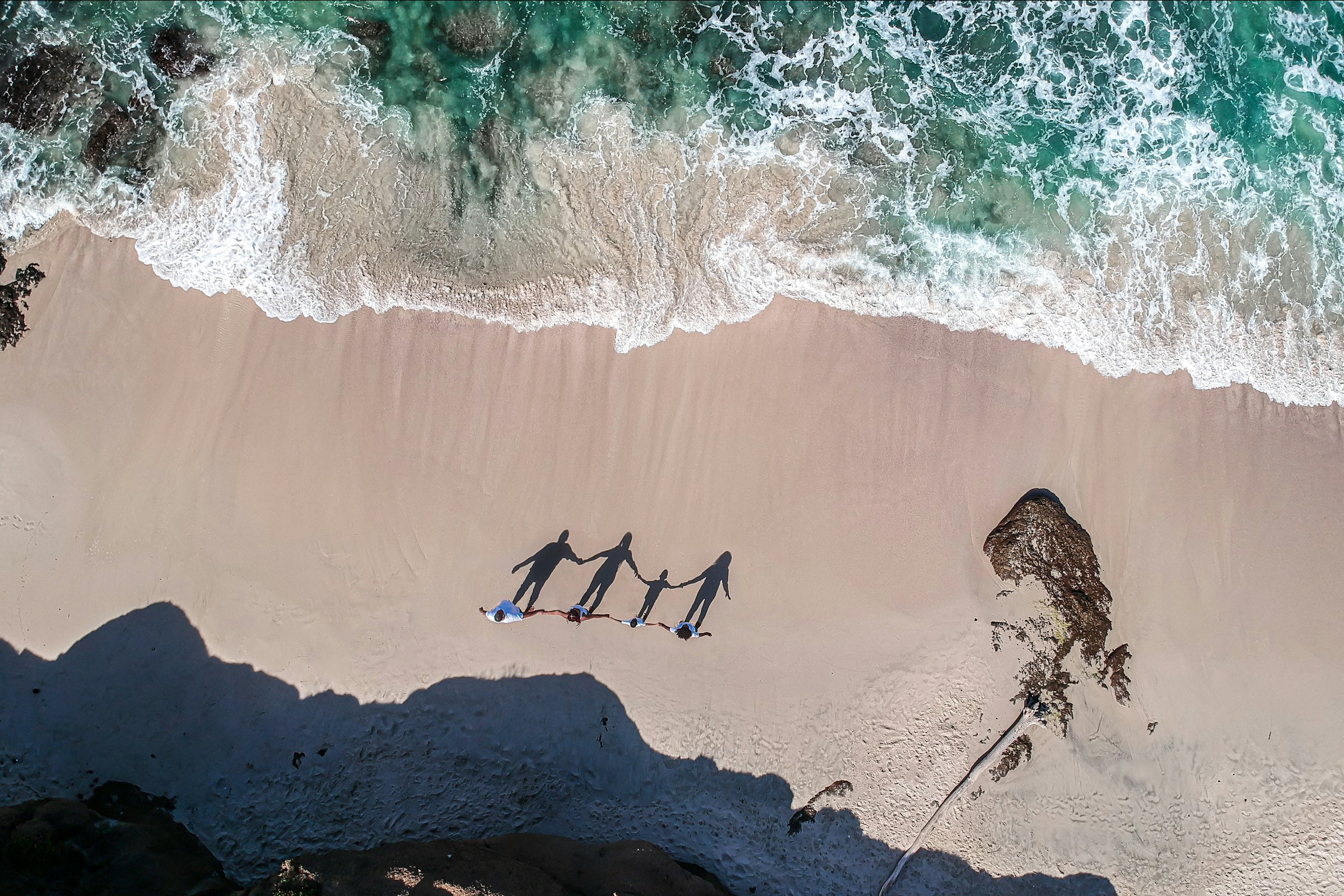 Travellers walking together along a beach, viewed from above