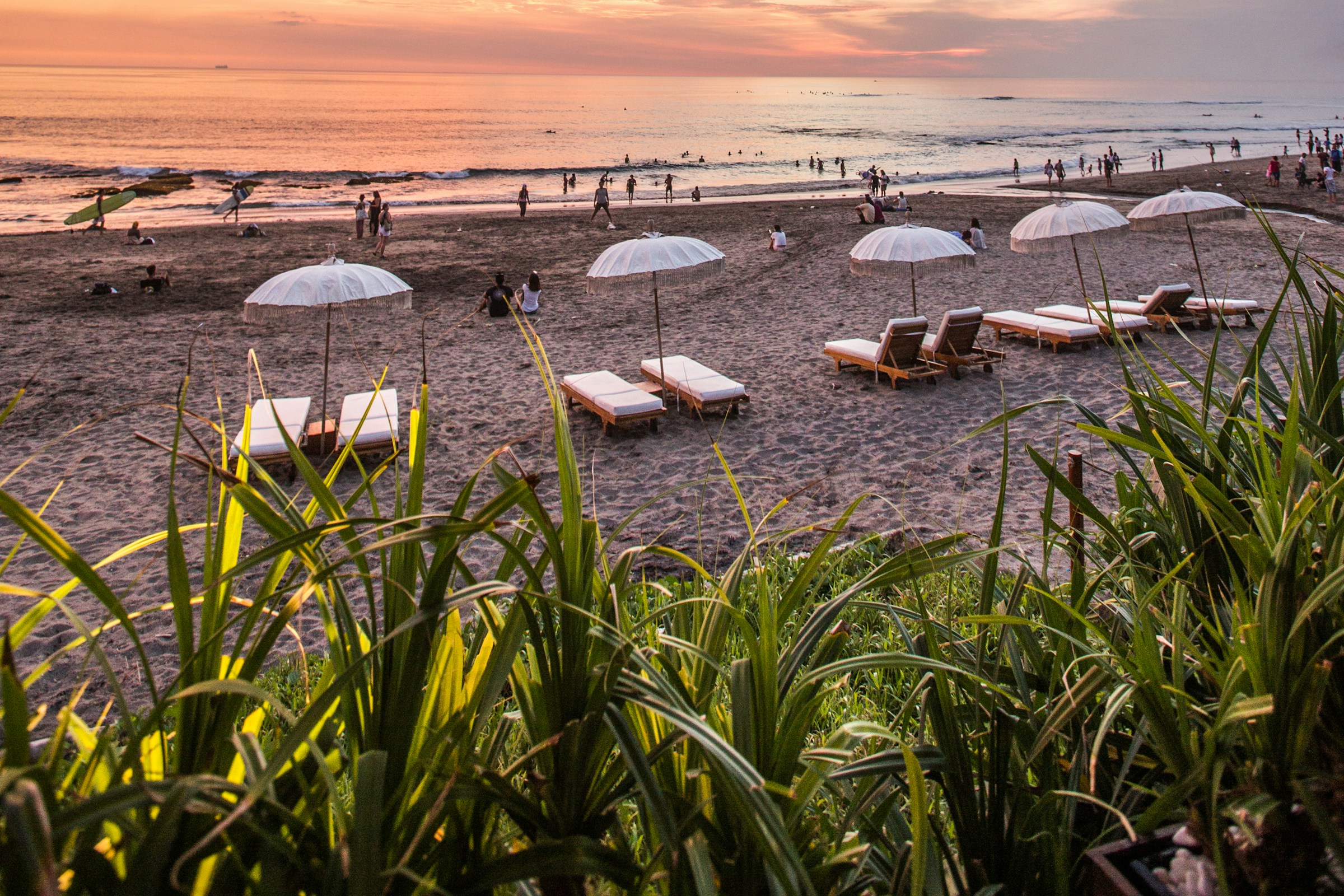 Seaside loungers and umbrellas overlooking the water at sunset