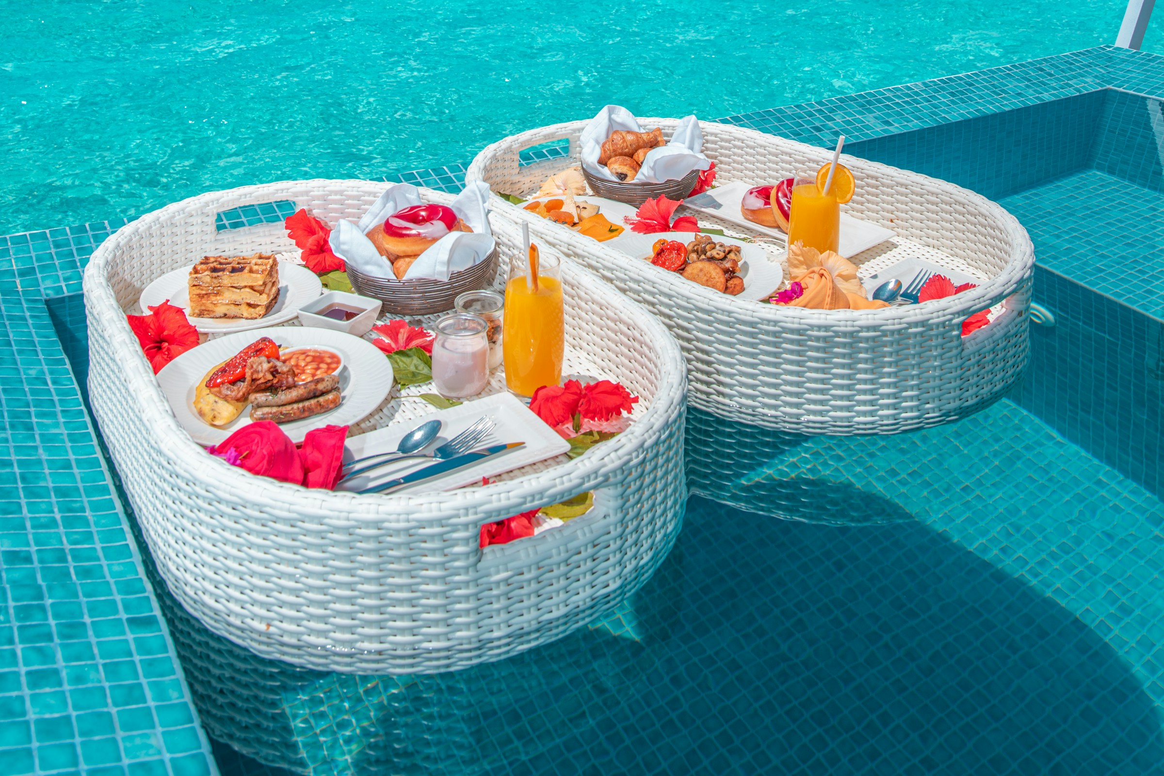 Breakfast served beside a pool overlooking a turquoise lagoon